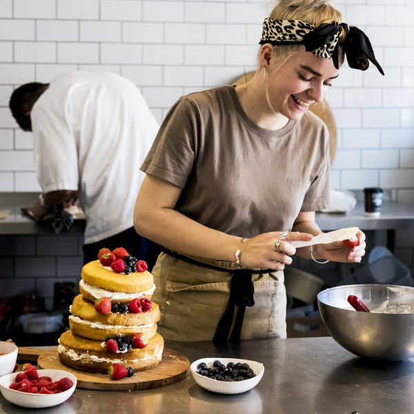 a-cook-working-in-a-commercial-kitchen-assembling-a-layered-sponge-cake-with-fresh-fruit-.jpg a-cook-working-in-a-commercial-kitchen-assembling-a-layered-sponge-cake-with-fresh-fruit-.jpg